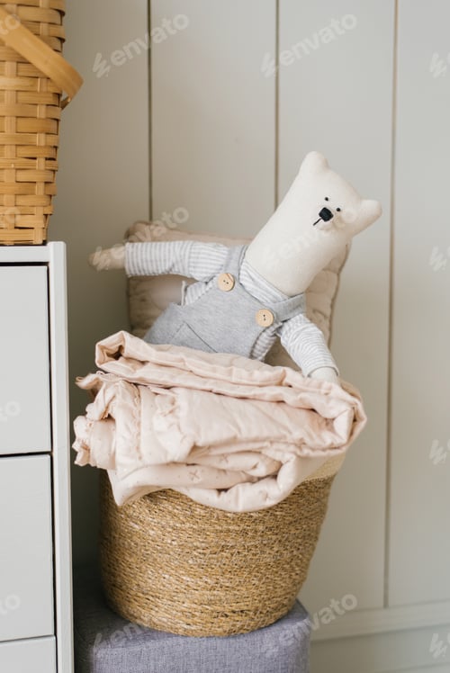 Preview: Stuffed Toy is a Homemade Teddy Bear on Basket with Laundry in the Decor of Children's Room