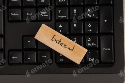 Preview: top view enter icon on wood block on keyboard on wooden table
