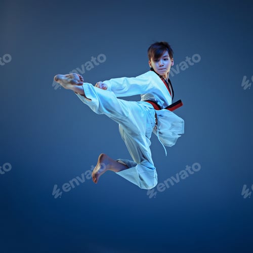 Preview: Young boy training karate on blue background
