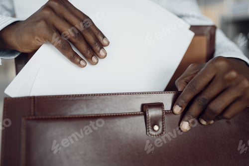 Preview: Black businessman holds briefcase in car showroom