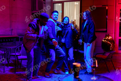 Preview: Friends enjoying a lively celebration at a vibrant outdoor gathering at night in a cozy courtyard