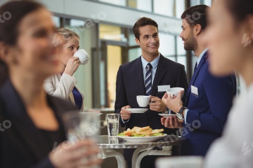 Preview: Businesspeople interacting with each other while having coffee