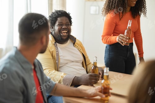 Preview: Health! photo of happy multi ethnic friends celebrating and having fun while drinking a beer