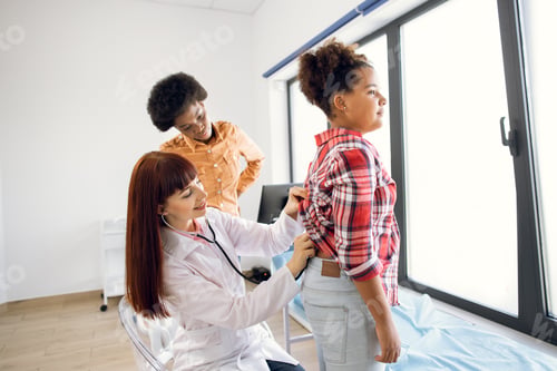 Preview: Symptoms of pneumonia and virus infection in children concept. Pretty 30-aged gp doctor listens to