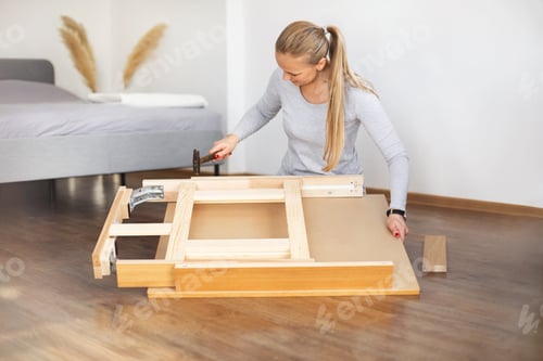 Preview: Young woman collects new furniture at home after renovation