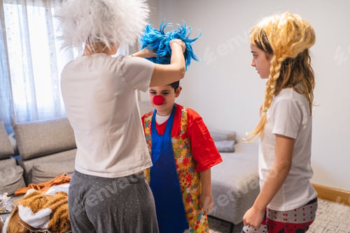 Preview: Mother helping children trying on carnival costumes at home