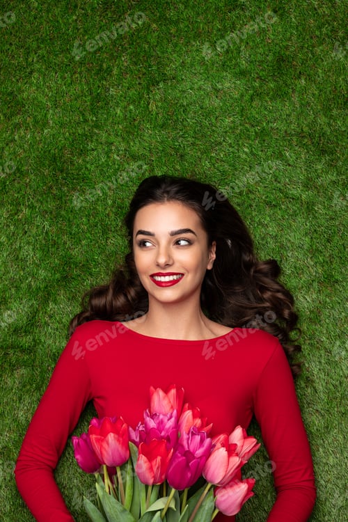 Preview: Pretty girl with pink tulips on lawn