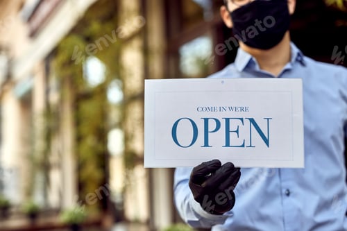 Preview: Close-up of waiter holding open sign while reopening cafe after coronavirus epidemic.