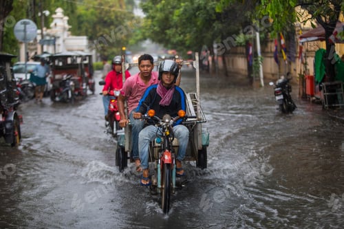 Preview: Motorcyclists navigating a flooded city street.