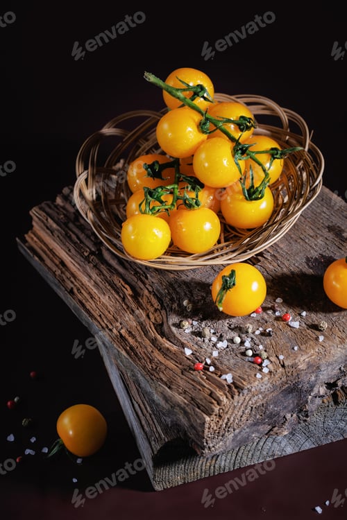 Preview: Yellow cherry tomatoes in basket with sea salt on rustic wood