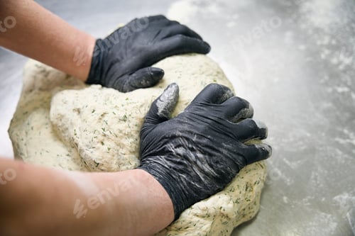 Preview: Kitchen worker kneads a large piece of dough by hand