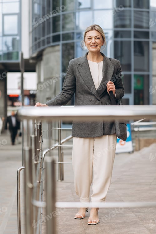 Preview: Portrait of a mature business woman smiling with emotions on a modern office and urban background