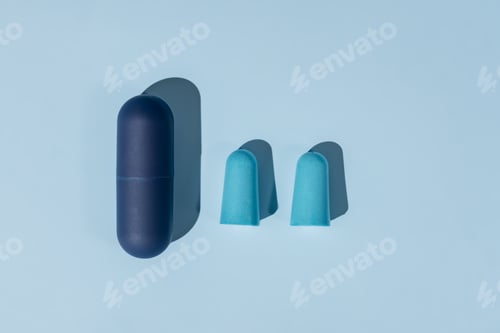 Preview: Blue ear plugs made of foam for comfortable sleep on blue background. Insomnia concept, flat lay