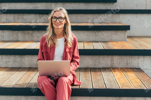 Preview: A woman with a laptop is sitting on the terrace.