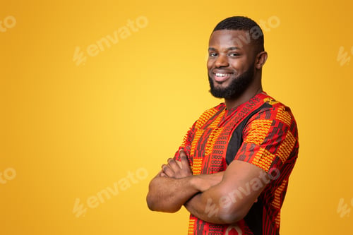 Preview: Confident smiling guy in bright traditional t-shirt over yellow