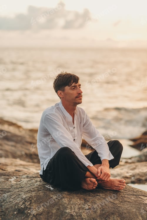 Preview: man meditating on the ocean