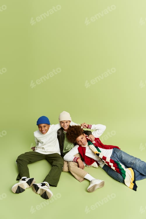 Preview: Vibrant little boys showcase friendship in stylish outfits on a playful green backdrop