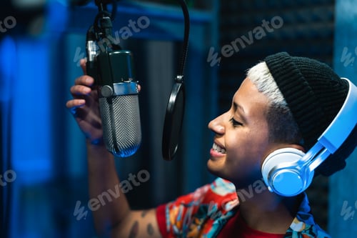 Preview: Young professional female singer recording a new song album inside music production studio