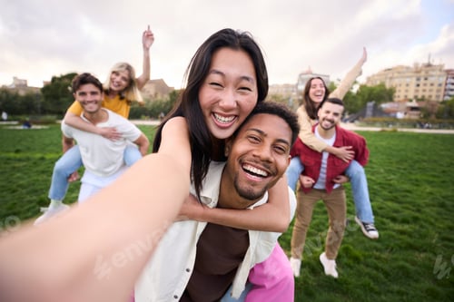 Visualização: Grupo multirracial de amigos tirando uma foto de selfie andando pelo parque, abraçando casais e sorrindo.