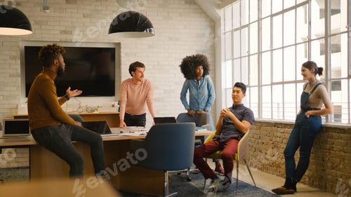 Preview: Young Multi Cultural Business Team Meeting Around Desk In Modern Office