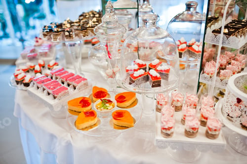 Preview: Different sweets and cupcakes at catering wedding reception table.