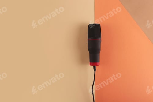 Preview: Podcasting concept - microphone at blogger's workplace on a combined beige background.