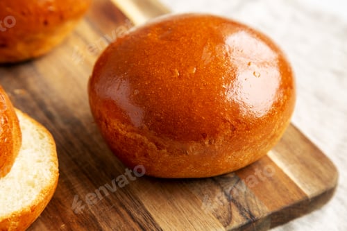 Preview: Homemade Brioche Hamburger Buns on a wooden board, side view. Close-up.
