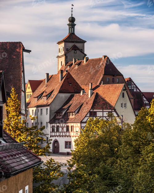 Preview: View of a historic building with a clock tower against blue sky in Rothenburg ob der Tauber, Germany