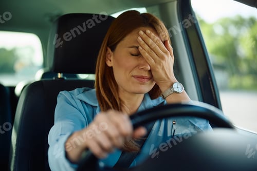 Preview: Upset woman behind the steering wheel of a car.