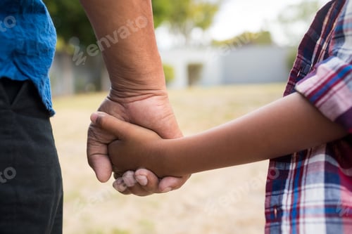 Preview: Cropped image of boy and grandfather holding hands