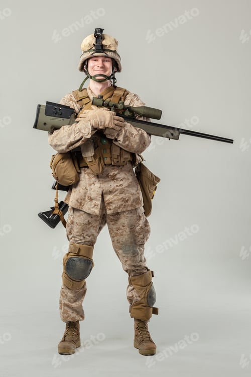 Preview: Soldier in military attire holds a rifle while standing on a neutral backdrop