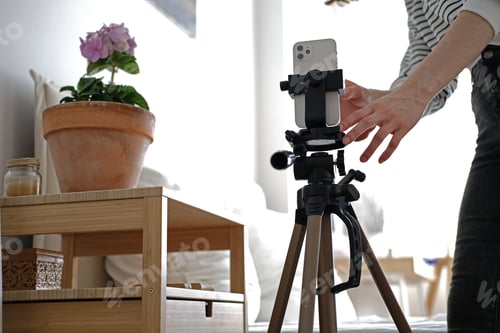 Preview: Young woman blogger making a video for her blog using phone camera at home.