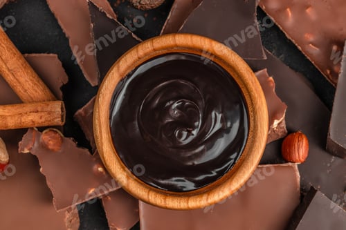 Preview: Dark chocolate sauce in bowl with chocolate pieces top view