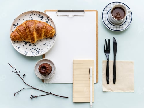 Preview: Aerial view of croissant coffee cup and paper clipboard
