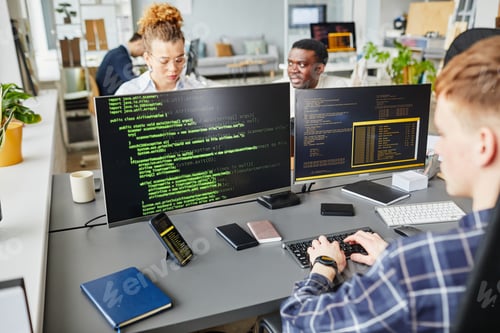 Preview: IT specialists working with codes on computers