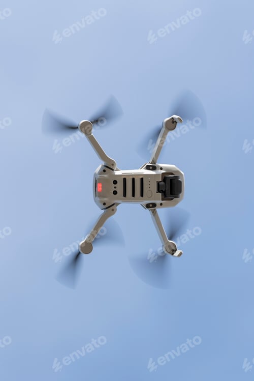 Preview: Bottom view of a drone flying with the light blue sky on the background