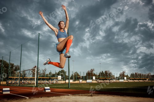 Preview: Female athlete performing a long jump during a competition