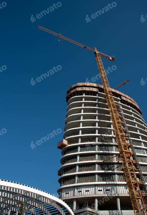 Preview: Residential office building construction site and cranes during a vibrant summer day with blue sky
