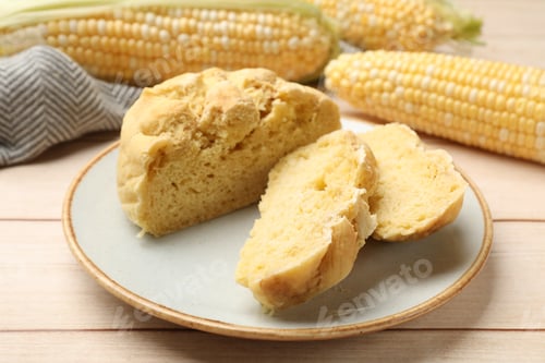 Preview: Freshly baked cornbread and cobs on wooden table, closeup