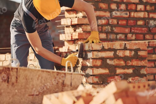 Preview: Busy with brick wall. Construction worker in uniform and safety equipment have job on building