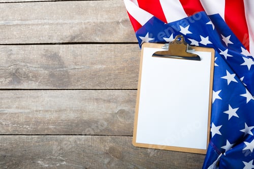 Preview: blank clip board and USA flag on wooden background