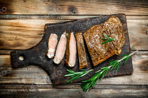 Preview: Sliced grilled beef steak with rosemary.