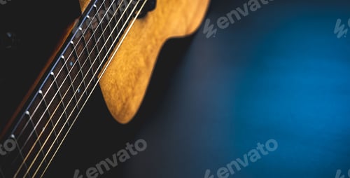 Preview: Acoustic guitar, music instrument resting against a dark black background with copy space