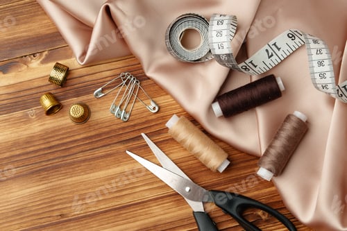 Preview: Sewing tools and materials arranged on soft fabric showcasing essential crafting supplies for
