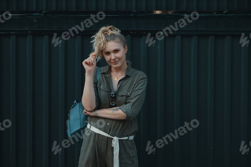 Preview: Woman with Blond Hair Poses Against Dark Wall