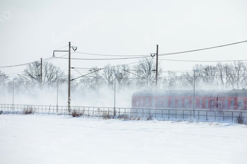 Preview: Passenger train passing through snowy landscape on winter day