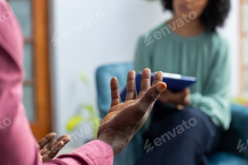 Preview: Midsection of african american male patient attending therapy with biracial female therapist