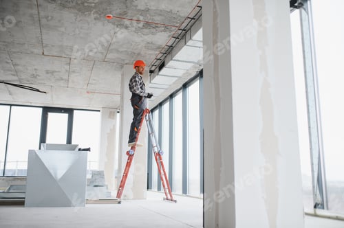 Preview: Construction worker installing ventilation system on a ladder in building under construction