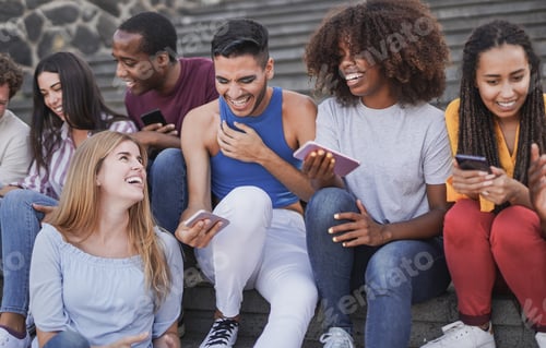 Preview: Group of multiracial people using mobile phone outdoor - Young diverse friends enjoy day in the city