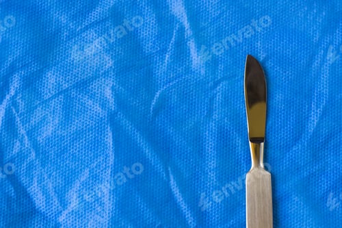 Preview: Top view of a scalpel on a blue surface in the hospital